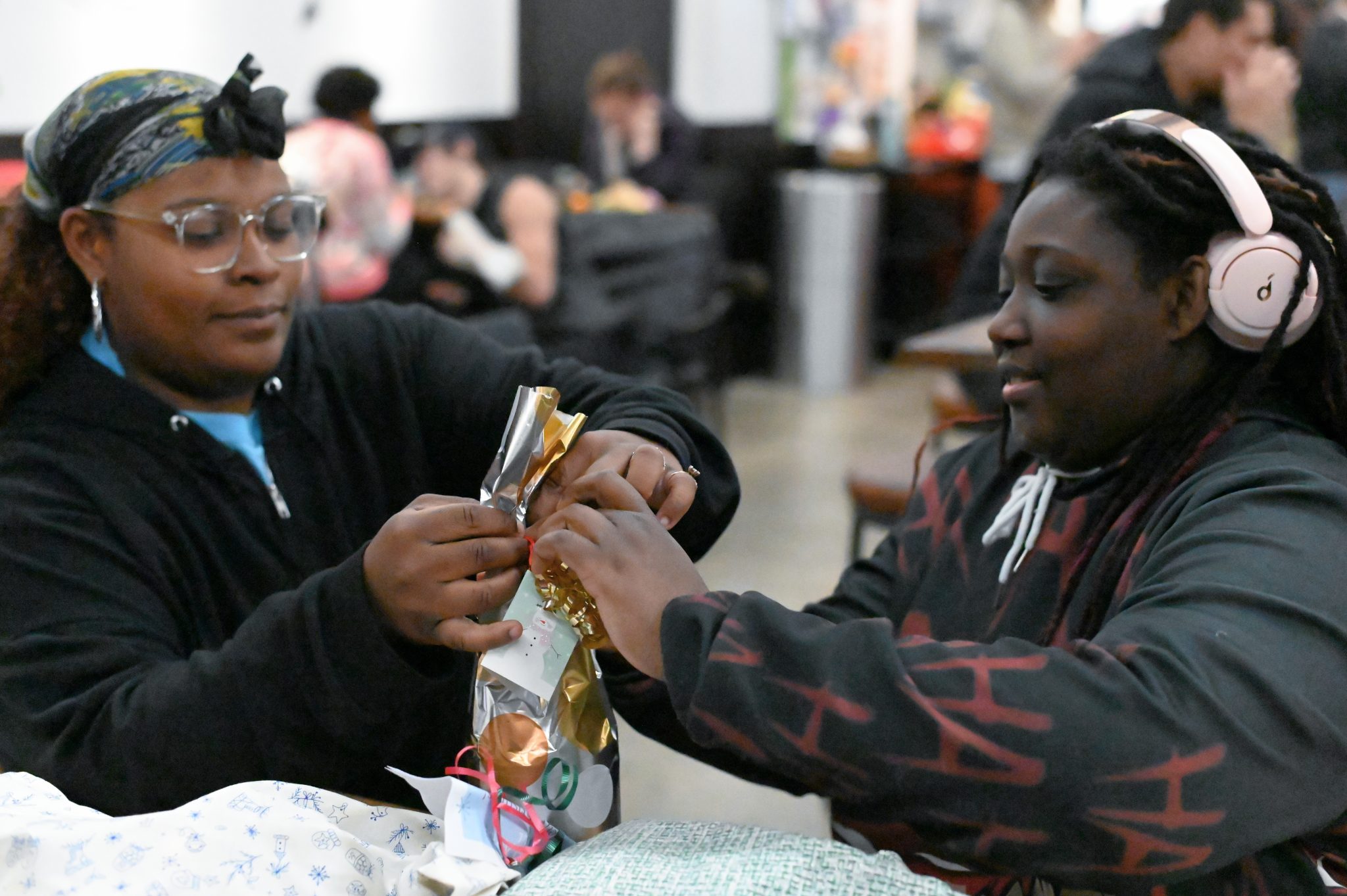 ALEYA WHITE two youth open a gift at the Family Christmas Party